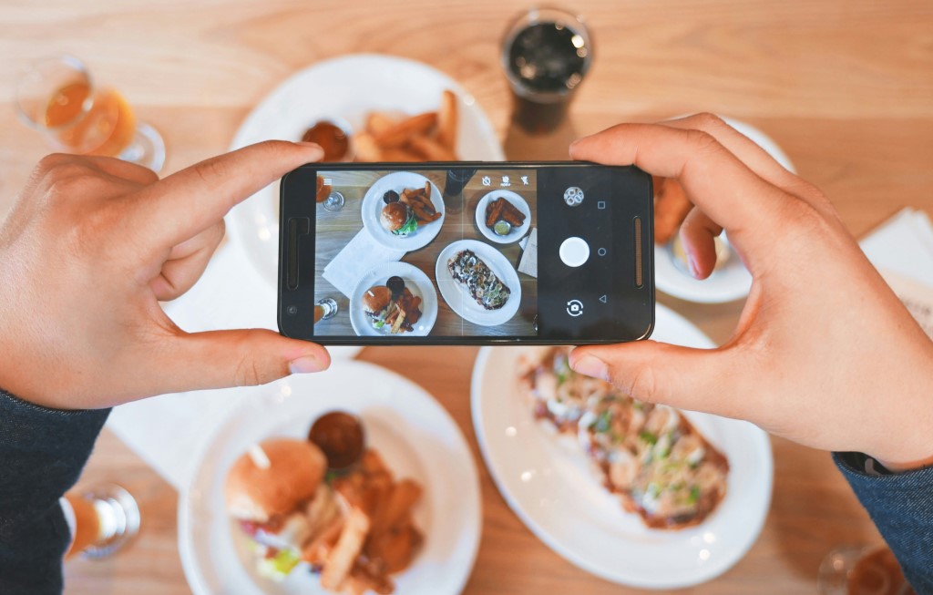 イメージ画像、スマホで料理の写真を撮る様子