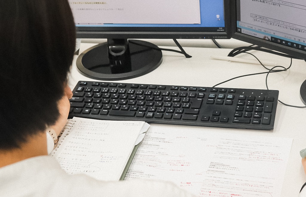 ライターがパソコン画面に向かってライティング業務をしている画像